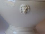 a white vase with a lion head on it
