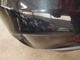 a close up of a car ' s rear end with a reflection of a person