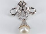 a close up of a white pearl pendant on a silver chain
