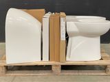 a white toilet sitting on a pallet next to a book