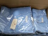 une boîte remplie de chemises bleues emballées dans du plastique