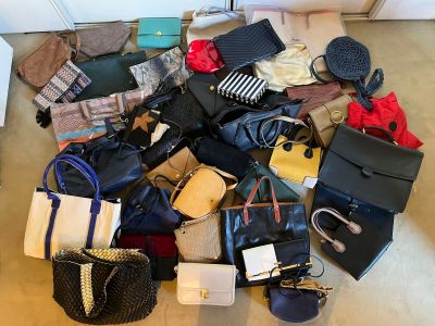 a pile of purses and handbags sitting on the floor