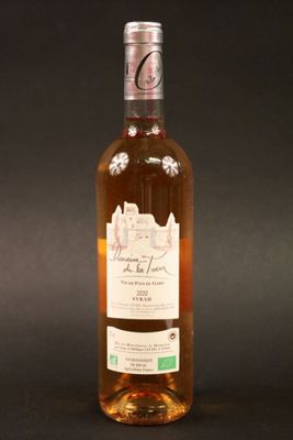 une bouteille de vin posée sur une table à côté d'un verre