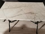 a white marble table with a black chair in the background