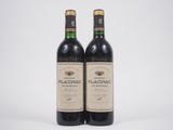 deux bouteilles de vin rouge posées l'une à côté de l'autre sur une surface blanche