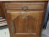 a wooden cabinet that has a drawer on top of it