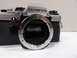 a black and silver camera sitting on a white table