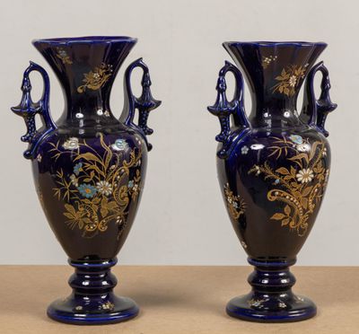 une paire de vases bleus ornés de motifs dorés, posés sur une table