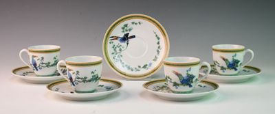 five cups and a saucer with a bird on them