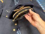 a person holding a hat and a jacket on a chair