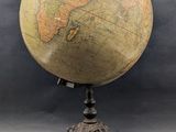 un vieux globe terrestre posé sur un trépied, avec un fond noir