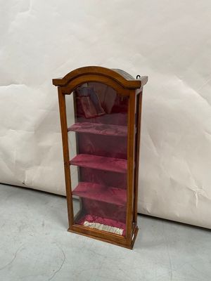 a small wooden display case with pink shelves in it
