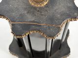 a black and gold table with a flower decoration on top of it