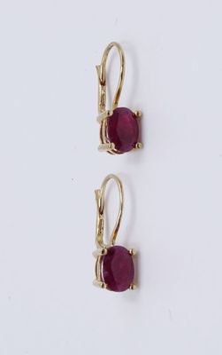deux paires de boucles d'oreilles ornées de pierres rouges sur un fond blanc