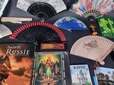a table with a bunch of books and a fan on it
