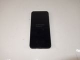 a black samsung phone sitting on a white table