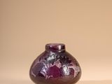 a purple vase sitting on a table with a white background