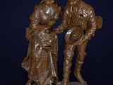 bronze statue of a man and a woman holding a basket