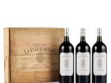 three bottles of red wine in front of a wooden box