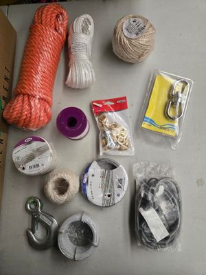 une table sur laquelle se trouvent un tas de pelotes de laine, des ciseaux et d'autres objets