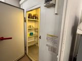 a small refrigerator in a small room with a door open
