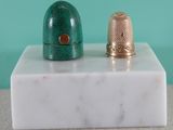 deux dés à coudre posés sur un bloc de marbre