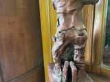 a statue of a man sitting on top of a wooden table