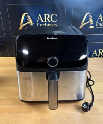 une friteuse à air chaud noire et argentée posée sur une table en bois