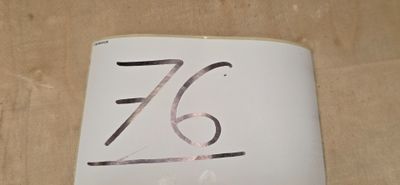 une photo d'une plaque indiquant le numéro d'une maison, posée sur une table
