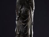 an image of a statue of a person standing on a black surface