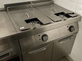 une plaque de cuisson en acier inoxydable dans une cuisine au sol carrelé
