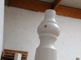 many white vases sitting on a table in a room