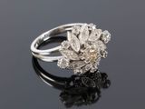 a close up of a diamond and white gold ring on a black surface