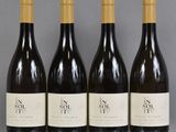 four bottles of wine are lined up on a table