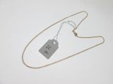a close up of a tag on a chain on a white surface