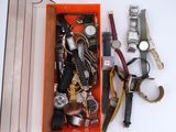 an orange box filled with assorted watches and other items