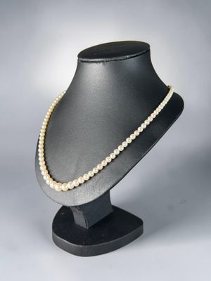 a close up of a mannequin with pearls on it