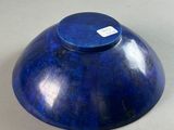 a blue bowl sitting on a table with a tag on it
