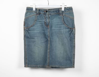 un gros plan d'une jupe en jean suspendue à un cintre