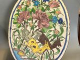 a plate with a bird and flowers on it next to a vase