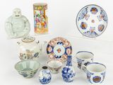 une collection de céramiques asiatiques exposée sur un fond blanc