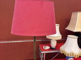 une table sur laquelle sont posées deux lampes et un tapis rouge sur le sol