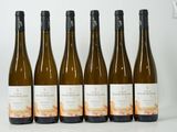 six bouteilles de vin sont alignées sur une table