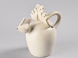 a white vase with a bird on top of it