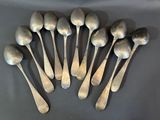 six silver spoons are arranged in a circle on a table