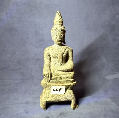 statue représentant une personne assise sur un tabouret sur lequel est posé un badge nominatif