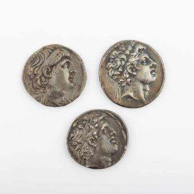 trois pièces romaines, dont l'une représente la tête d'une femme et une autre la tête d'un