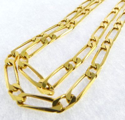 a close up of a gold chain necklace on a white surface