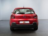 the rear of a red citrole parked in a white room