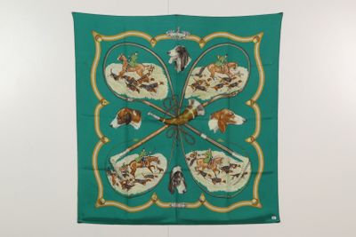 un foulard en soie vert orné d'un motif représentant des chiens, accroché au mur